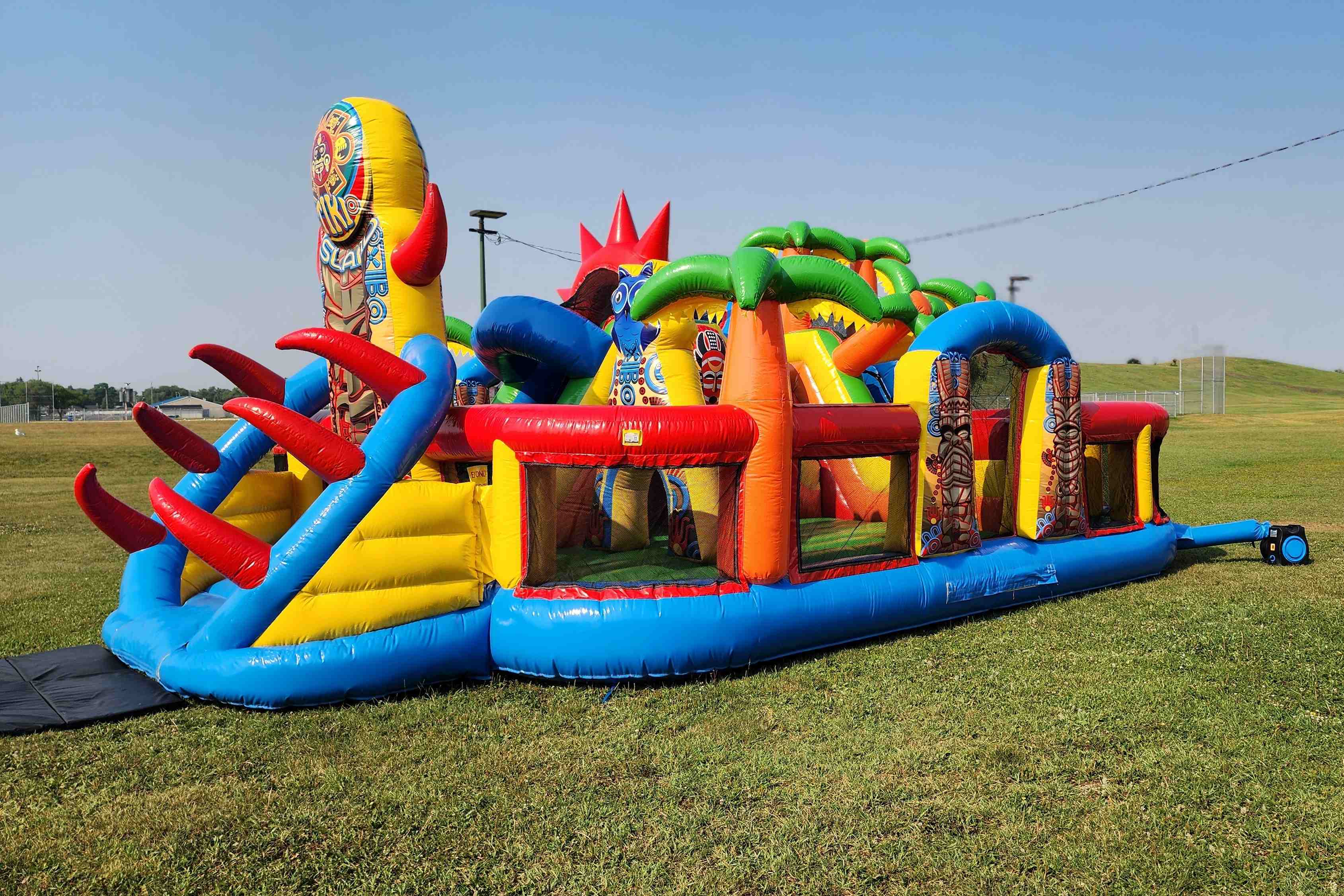 Large tropical Tiki Island Mega Playground bounce house with slides available in Kenora Ontario